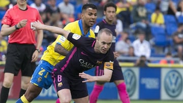 El centrocampista del FC Barcelona Andrés Iniesta escapa con el balón entre Jonathan Viera.