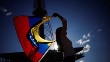 Mujer ondeando la bandera de Venezuela, uno de los países afectados por las restricciones de viaje de Trump.
