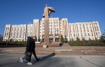 Dos viandantes pasean delante de la estatua de Lenin en Tiraspol.