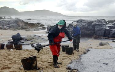Voluntarios y trabajadores recogen el fuel de las playas.