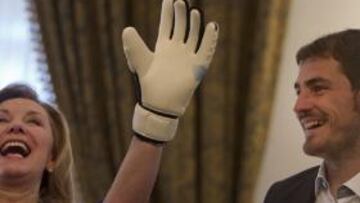 La primera dama chilena Cecilia Morel bromea con unos guantes de arquero junto al portero de la selección española y del Real Madrid Iker Casillas hoy, martes 14 de junio de 2011, durante una audiencia en el palacio La Moneda, en Santiago (Chile).