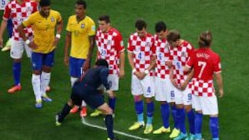 Imagen del árbitro, en un partido del Mundial, señalando el lugar de la barrera con el espray.