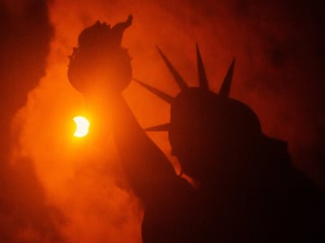 La Estatua de la Libertad de Nueva York contempl el fenmeno que ti?o de luz naranja y oscuridad el pas.