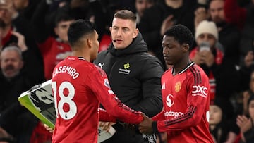 Manchester United's Brazilian midfielder #18 Casemiro (L) goes off to be replaced by Manchester United's English midfielder #37 Kobbie Mainoo (R) reacts during the English Premier League football match between Manchester United and Bournemouth at Old Trafford in Manchester, north west England, on December 15, 2025. (Photo by PETER POWELL / AFP) / RESTRICTED TO EDITORIAL USE. No use with unauthorized audio, video, data, fixture lists, club/league logos or 'live' services. Online in-match use limited to 120 images. An additional 40 images may be used in extra time. No video emulation. Social media in-match use limited to 120 images. An additional 40 images may be used in extra time. No use in betting publications, games or single club/league/player publications. /