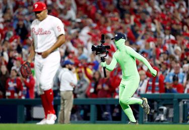 Curiosa imagen en la que se ve a un cámara vestido de verde. No se trata de un espontáneo disfrazado por la fiesta de Halloween, es un croma humano ataviado de esa forma para que su imagen no sea captada por la televisión que transmite el partido de las Series Mundiales que enfrenta a Phillies y Astros por el título.