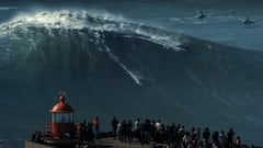 Nic Von Rupp surfeando una ola en Praia do Norte, Nazaré (Portugal). Visto desde los acantilados, con púbico y el faro en primer plano.