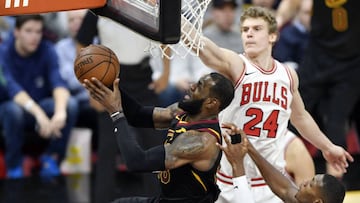 LeBron James trata de anotar entre Lauri Markkanen y Kris Dunn.