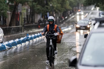 Un repartidor trabaja bajo la lluvia en Madrid (España). 