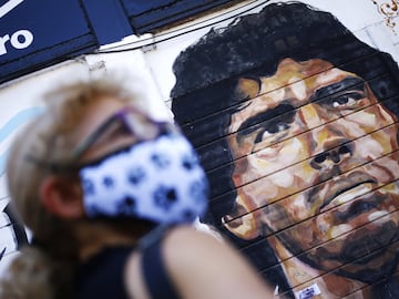 A woman stands in front of a mural of Diego Maradona outside Argentinos Juniors Club at Paternal neighbourhood on November 27, 2020 in Buenos Aires, Argentina.