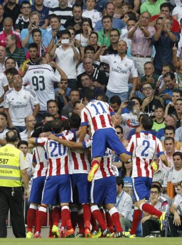 Los jugadores del Atlético de Madrid celebran el gol marcado por su compañero Tiago al Real Madrid, durante el partido de la tercera jornada de Liga de Primera División, disputado esta tarde en el estadio Santiago Bernabéu.