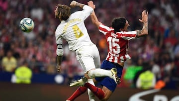 TOPSHOT - Real Madrid's Spanish defender Sergio Ramos (L) and Atletico Madrid's Montenegrin defender Stefan Savic jump for the ball during the Spanish league football match between Club Atletico de Madrid and Real Madrid CF at the Wanda Metropol