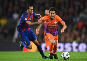 Sergio Busquets tussles with Spain teammate David Silva during Wednesday night's Champions League match