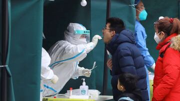 FILE PHOTO: A medical worker collects a swab sample from a resident at a makeshift nucleic acid testing site at a residential compound, following new confirmed cases of the coronavirus disease (COVID-19), in Beijing, China January 24, 2022. REUTERS/Tingshu Wang/File Photo