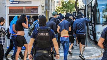 Soccer fans, most of them from Croatia, cover their faces while leaving the Athens Police Headquarters in Athens, as they are being detained as part of the inquiry on the death of a Greek fan during violent clashes on August 9, 2023. More than a hundred people, including 94 Croats, are to appear before the Athens prosecutor's office, suspected of being involved in the death of a Greek fan during violent clashes on August 7 evening between supporters of the Croatian football club Dinamo Zagreb and the 'Aek of Athens in the suburbs of the Greek capital. (Photo by YIANNIS PANAGOPOULOS / EUROKINISSI / AFP)