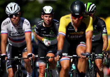 Mark Cavendish, ya atendido por los m¨¦dicos, cruza la l¨ªnea de meta con un grupo de ciclistas.