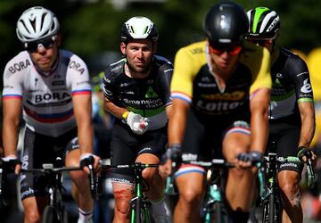 Mark Cavendish, ya atendido por los médicos, cruza la línea de meta con un grupo de ciclistas.