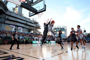 El portaviones estadounidense USS Abraham Lincoln se convirtió en una improvisada cancha de baloncesto para acoger el Clásico de las Fuerzas Armadas entre los Gonzaga Bulldogs y los Michigan State Spartans, en San Diego (California). En la imagen, Malachi Smith (13) intenta una entrada a canasta ante Jaxon Kohler (0).