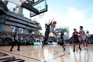 El portaviones estadounidense USS Abraham Lincoln se convirtió en una improvisada cancha de baloncesto para acoger el Clásico de las Fuerzas Armadas entre los Gonzaga Bulldogs y los Michigan State Spartans, en San Diego (California). En la imagen, Malachi Smith (13) intenta una entrada a canasta ante Jaxon Kohler (0).
