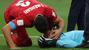 Iran's defender #03 Ehsan Hajsafi (L) speaks with his goalkeeper #01 Alireza Beiranvand following a crash of heads with Iran's defender #19 Majid Hosseini during the Qatar 2022 World Cup Group B football match between England and Iran at the Khalifa International Stadium in Doha on November 21, 2022. (Photo by Adrian DENNIS / AFP)