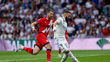 MADRID, 24/05/2023.- El delantero francés del Real Madrid, Karim Benzema (d), controla el balón ante el defensa francés del Rayo Vallecano, Florian Lejeune, durante el encuentro correspondiente a la jornada 36 disputado hoy miércoles en el estadio Santiago Bernabéu, en Madrid. EFE / Rodrigo Jiménez.
