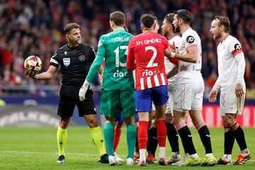 Los jugadores del Sevilla protestan a  Gil Manzano por la decisión de revocar la pena máxima tras revisar la jugada en el VAR.