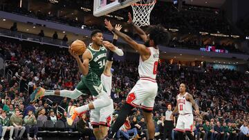 Giannis Antetokounmpo #34 of the Milwaukee Bucks looks to pass around Coby White #0 of the Chicago Bulls during the second half of a game at Fiserv Forum on December 11, 2023 in Milwaukee, Wisconsin.