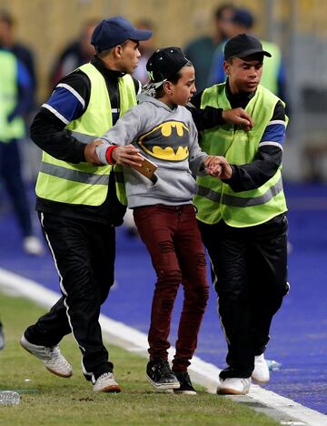 Un espontáneo es sacado del campo por la seguridad del estadio.