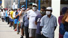 Un grupo de personas hace cola en una sucursal bancaria en un distrito de Lima para recibir el subsidio de 380 soles (90 euros) que otorga el Gobierno de Per&uacute; durante la crisis de la pandemia.