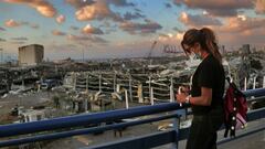 09 August 2020, Lebanon, Beirut: A Lebanese woman tries to light a candle near the site where a massive explosion blasted the port of Beirut on the afternoon of 04 August which killed at least 158 people, wounded 6000 and displaced some 250,000 to 300,000