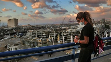 09 August 2020, Lebanon, Beirut: A Lebanese woman tries to light a candle near the site where a massive explosion blasted the port of Beirut on the afternoon of 04 August which killed at least 158 people, wounded 6000 and displaced some 250,000 to 300,000