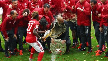 MUNICH, GERMANY - MAY 14: Head coach Josep Guardiola (C) of Bayern Muenchen is poured beer by David Alaba while celebrating Bundesliga champions with staffs after the Bundesliga match between FC Bayern Muenchen and Hannover 96 at Allianz Arena on May 14, 2016 in Munich, Germany. (Photo by Dean Mouhtaropoulos/Bongarts/Getty Images)