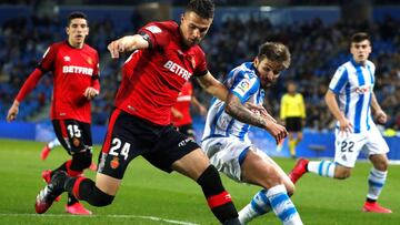 Cristian Portugués 'Portu (d) de la Real Sociedad y el eslovaco Martin Valjent del RCD Mallorca, durante el partido de la jornada 21 de LaLiga Santander disputado este domingo en el Reale Arena de San Sebastián.