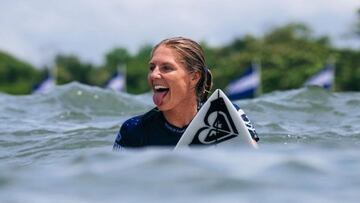 La 8 veces campeona del mundo de surf, Stephanie Gilmore, sacando la lengua sobre su tabla de surf en El Salvador.