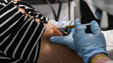(FILES) In this file photo taken on August 13, 2020, a volunteer receives a Covid-19 vaccination from Yaquelin De La Cruz at the Research Centers of America (RCA) in Hollywood, Florida. - The World Health Organization warned that vaccines were no magic bullet for the coronavirus crisis, as Russia started vaccinating its high-risk workers Saturday and other countries geared up for similar programmes. (Photo by CHANDAN KHANNA / AFP)