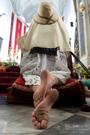 Una devota descalza en la iglesia Madonna del Carmine, en el sur de Italia, reza antes del sagrado sacramento.