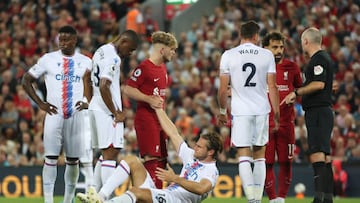 LIVERPOOL, ENGLAND - AUGUST 15: Joachim Andersen of Crystal Palace is helped by Harvey Elliott of Liverpool after Darwin Nunez (not pictured) was given a red card during the Premier League match between Liverpool FC and Crystal Palace at Anfield on August 15, 2022 in Liverpool, England. (Photo by Clive Brunskill/Getty Images)