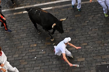 Participantes corren delante de los toros durante el primer encierro de los Sanfermines en Pamplona.