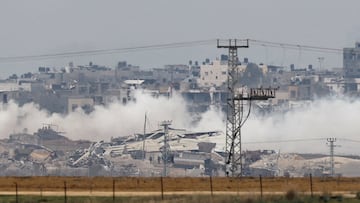 An Israeli military tank and soldiers operate in the Gaza Strip, amid the ongoing conflict between Israel and the Palestinian Islamist group Hamas, as seen from southern Israel, December 21, 2023. REUTERS/Clodagh Kilcoyne       TPX IMAGES OF THE DAY