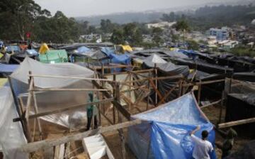 Miembros del Movimiento de los Trabajadores Sin Techo de Brasil (MTST) trabajan en la construcción de las chozas en el campamento "La Copa Mundial de los Pueblos", que alberga una estimación de 2.800 familias del movimiento.