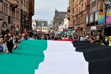 La gente sostiene una gran bandera palestina durante una protesta contra la participación israelí en el Festival de la Canción de Eurovisión.