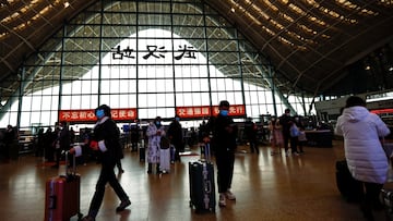 FILE PHOTO: People wait with luggages at a railway station, amid the coronavirus disease (COVID-19) outbreak, in Wuhan, Hubei province, China January 1, 2023. REUTERS/Tingshu Wang/File Photo