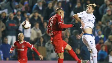 Mat&iacute;as Vi&ntilde;a, de blanco, salta de cabeza por delante de Paolo Guerrero durante un partido de Libertadores entre Nacional e Internacional.