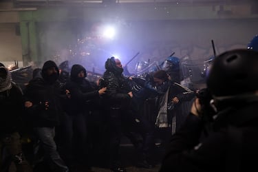 Agentes de policía se enfrentan a manifestantes que intentaban bloquear una carretera que conduce al estadio Santa Giulia, el día de una protesta contra el impacto ambiental, económico y social de los Juegos Olímpicos de Invierno Milano-Cortina 2026.