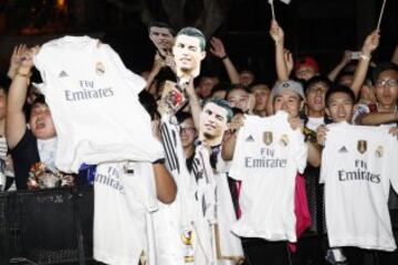 Seguidores del Real Madrid esperan con caretas de Cristiano Ronaldo y camisetas del club la llegada de sus ídolos.