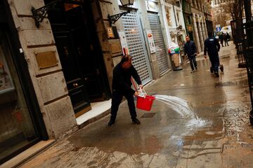 Un hombre limpia la acera cubierta del polvo sahariano traído por la tormenta Celia.