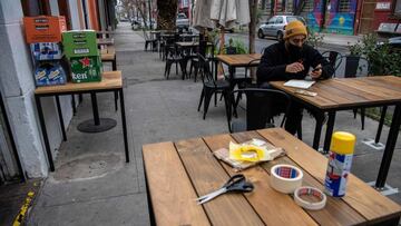 An employee sits at a table at a restaurant preparing to reopen as Chile's government allowed outdoor servicing in restaurants after easing some lockdown measures put into force amid the new coronavirus pandemic, in Santiago, on September 01, 2020. - Bars and restaurants - only outdoors - and other non-essential businesses will be able to open in several of the wealthiest neighborhoods of Santiago, Chilean health authorities confirmed Sunday, taking a step forward to the deconfinement of the capital, over five months after their closure due to the new coronavirus outbreak. (Photo by Martin BERNETTI / AFP)