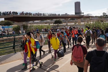 Los voluntarios de la zona de Valencia caminan, algunos con instrumentos de limpieza, para ayudar en las zonas afectadas del barrio de La Torre en Valencia. 