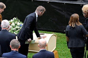 David Beckham toca el ataúd de Sven-Goran Eriksson en la casa donde continúa el servicio fúnebre. 
