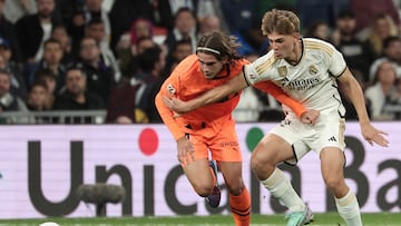 Valencia's Spanish defender #34 Yarek Gasiorowski (L) vies with Real Madrid's Argentinian midfielder #32 Nico Paz during the Spanish league football match between Real Madrid CF and Valencia CF at the Santiago Bernabeu stadium in Madrid on November 11, 2023. (Photo by Thomas COEX / AFP)