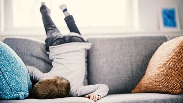 Cute child lying face down on the sofa. Tired boy after leisure activity and cheerful games.